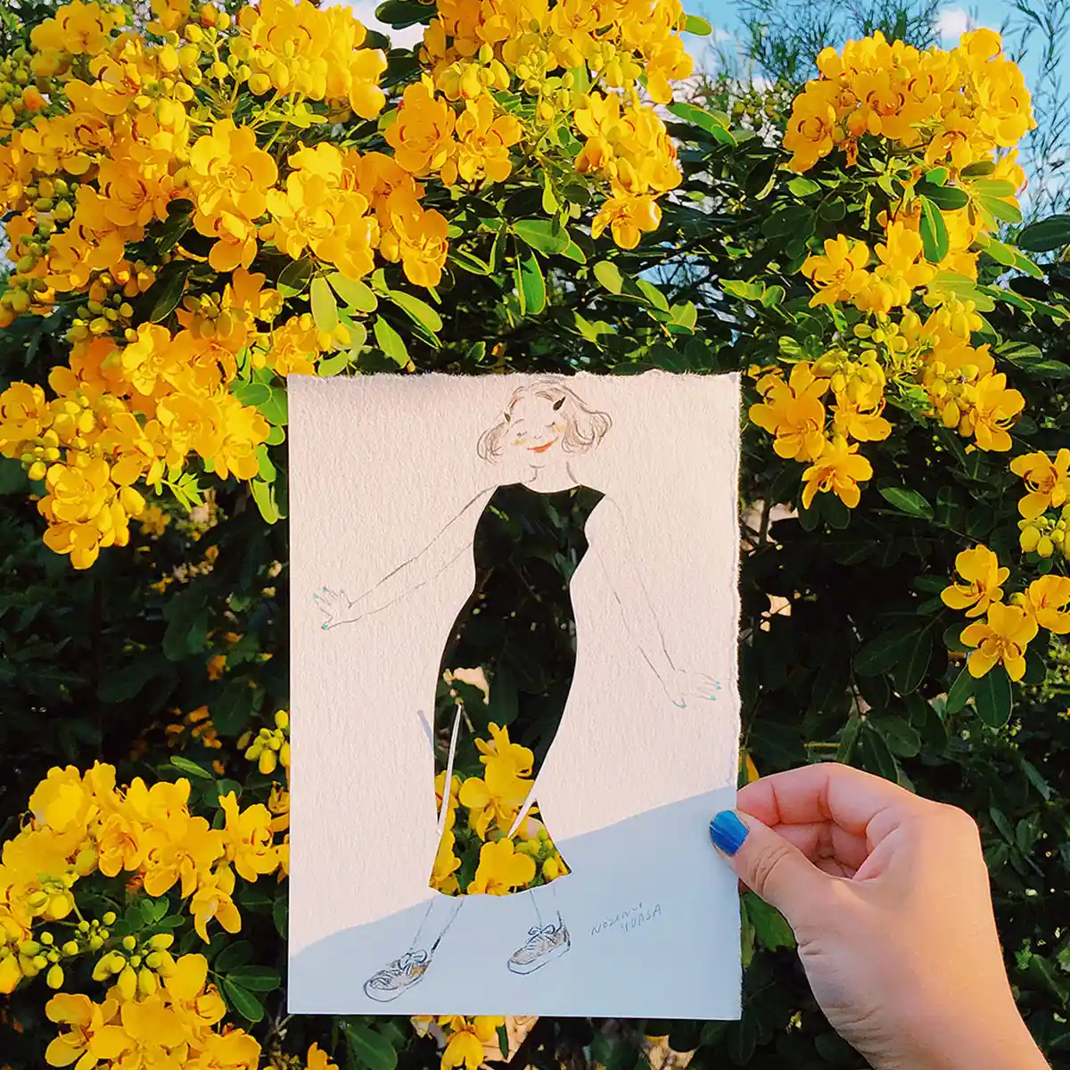 Illustrator Nozomi Yuasa creates an optical illusion with a stencil cut out of a woman revealing a backdrop of flowers.